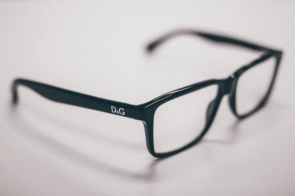 A pair of black prescription glasses on a white table