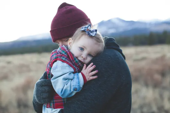A parent hugging a small child outdoors