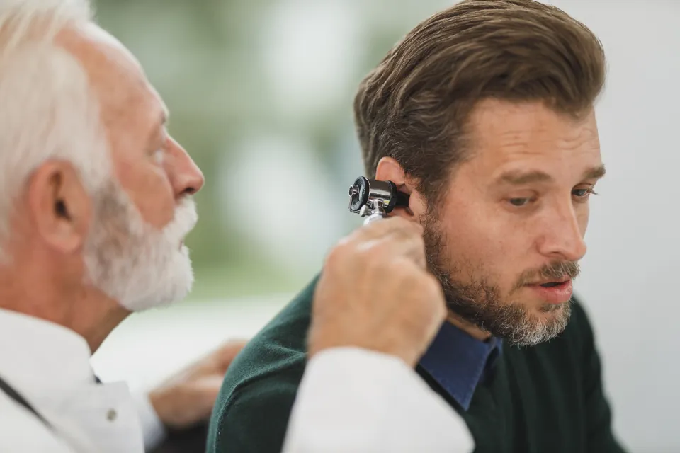 A doctor checks a patient's ear
